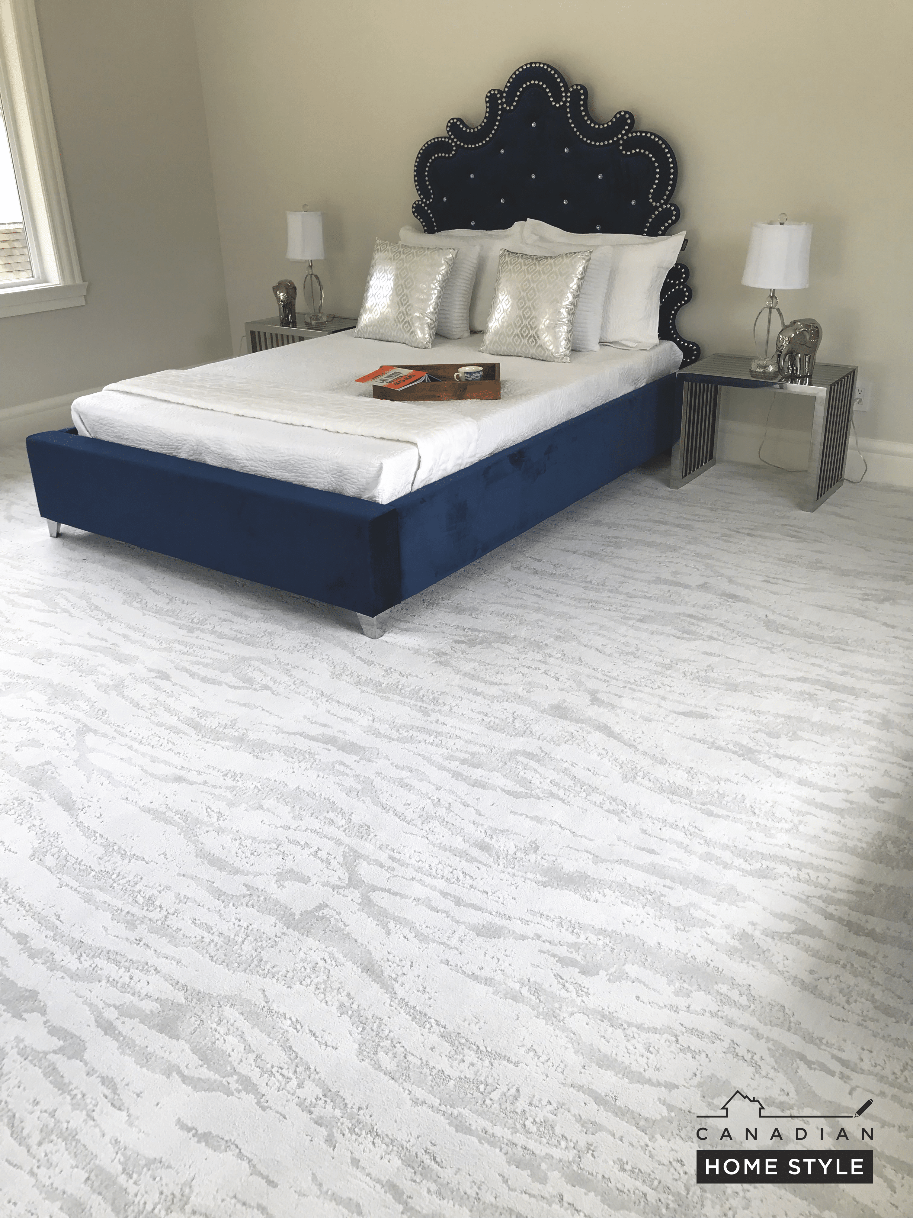 A bedroom with white walls and a blue bed.