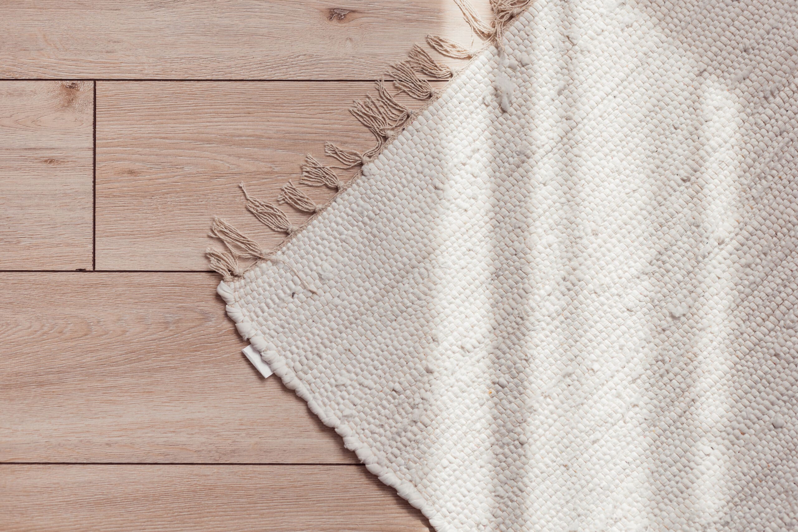 A white rug accents a beautiful wooden floor in Vancouver.