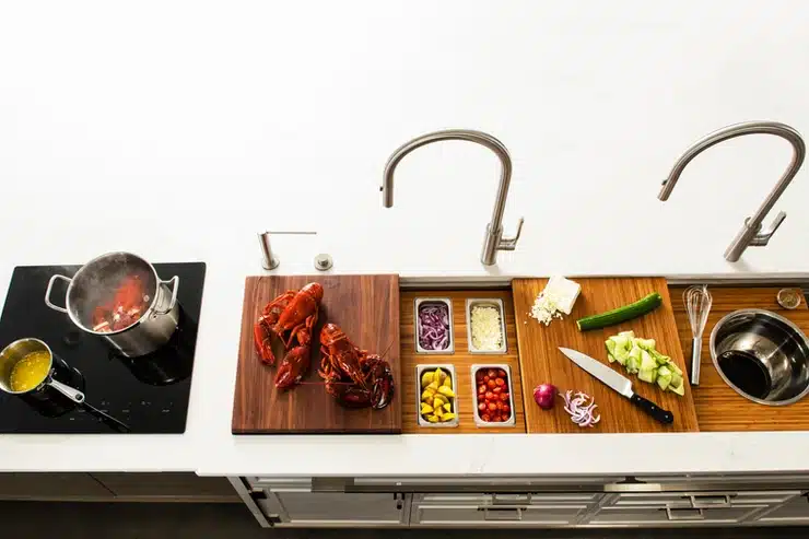 A Galley Workstation kitchen sink with a cutting board and utensils.