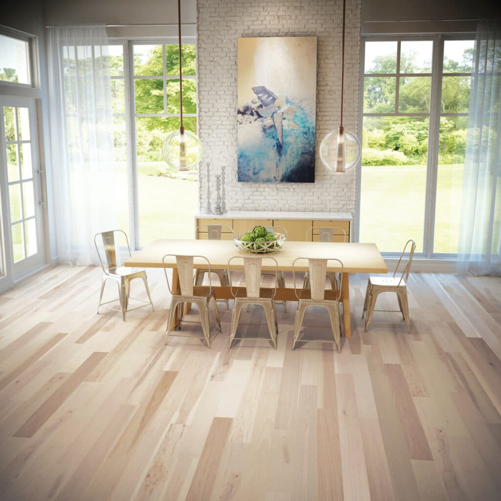A dining room with white walls and wood floors installed using nails.