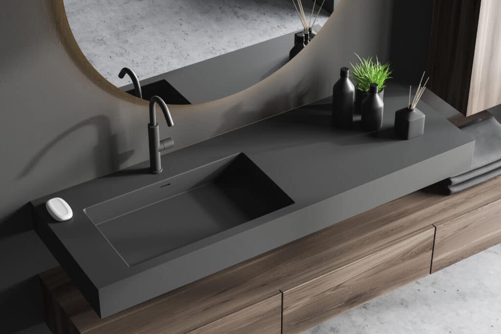 A modern bathroom with a grey sink and mirror featuring a modern bathroom vanity.