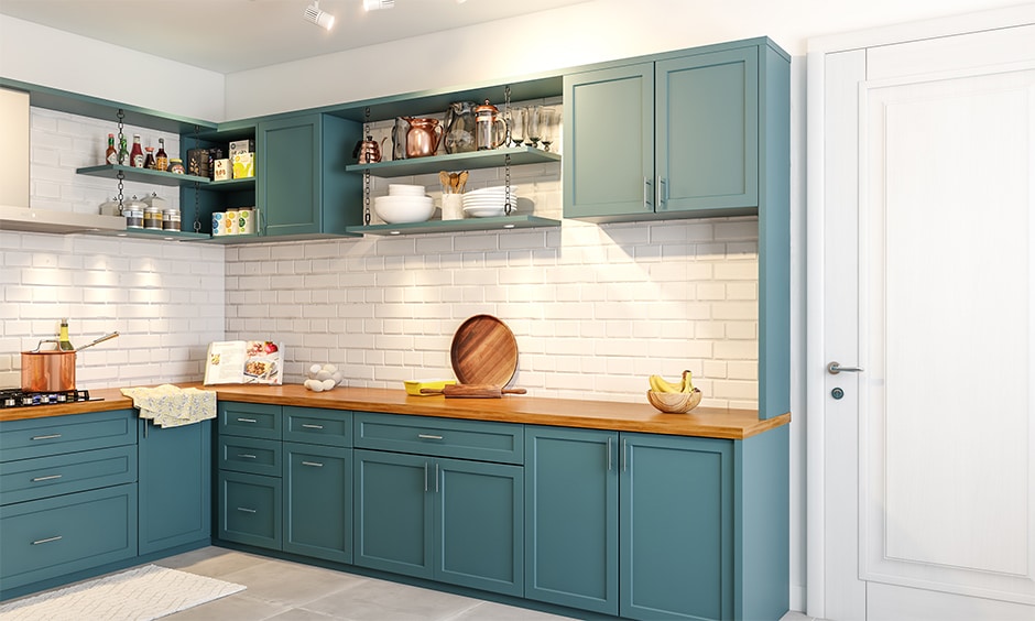 A kitchen with blue cabinets and white brick walls.