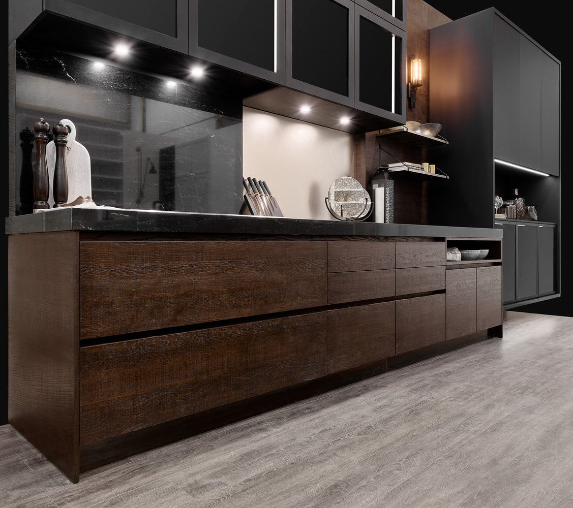 A modern kitchen renovation in Vancouver featuring dark cabinets and wood floors.