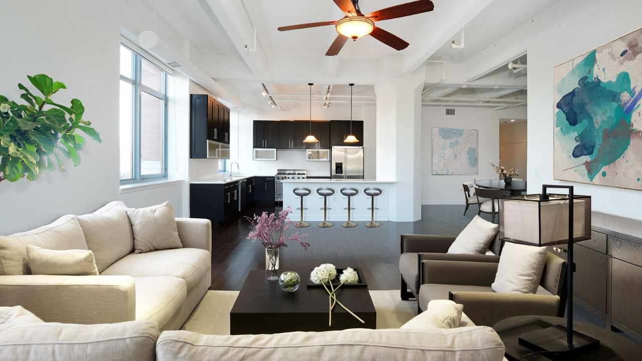 A living room with a ceiling fan and couches.