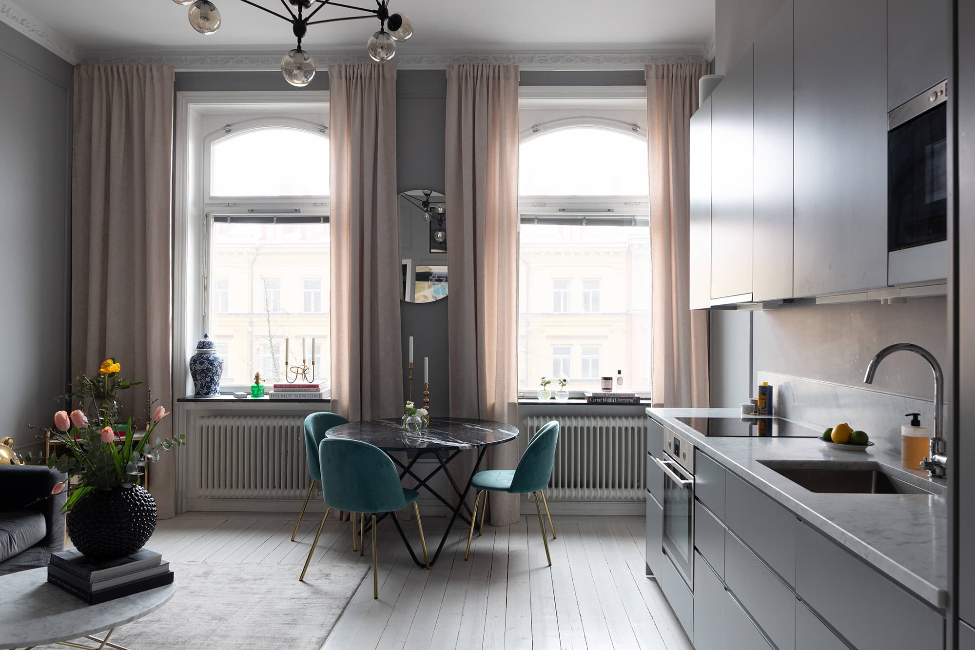 A grey apartment with a dining table and chairs.