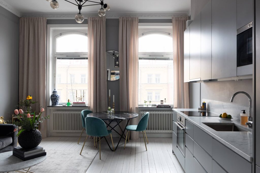 A grey apartment with a dining table and chairs.