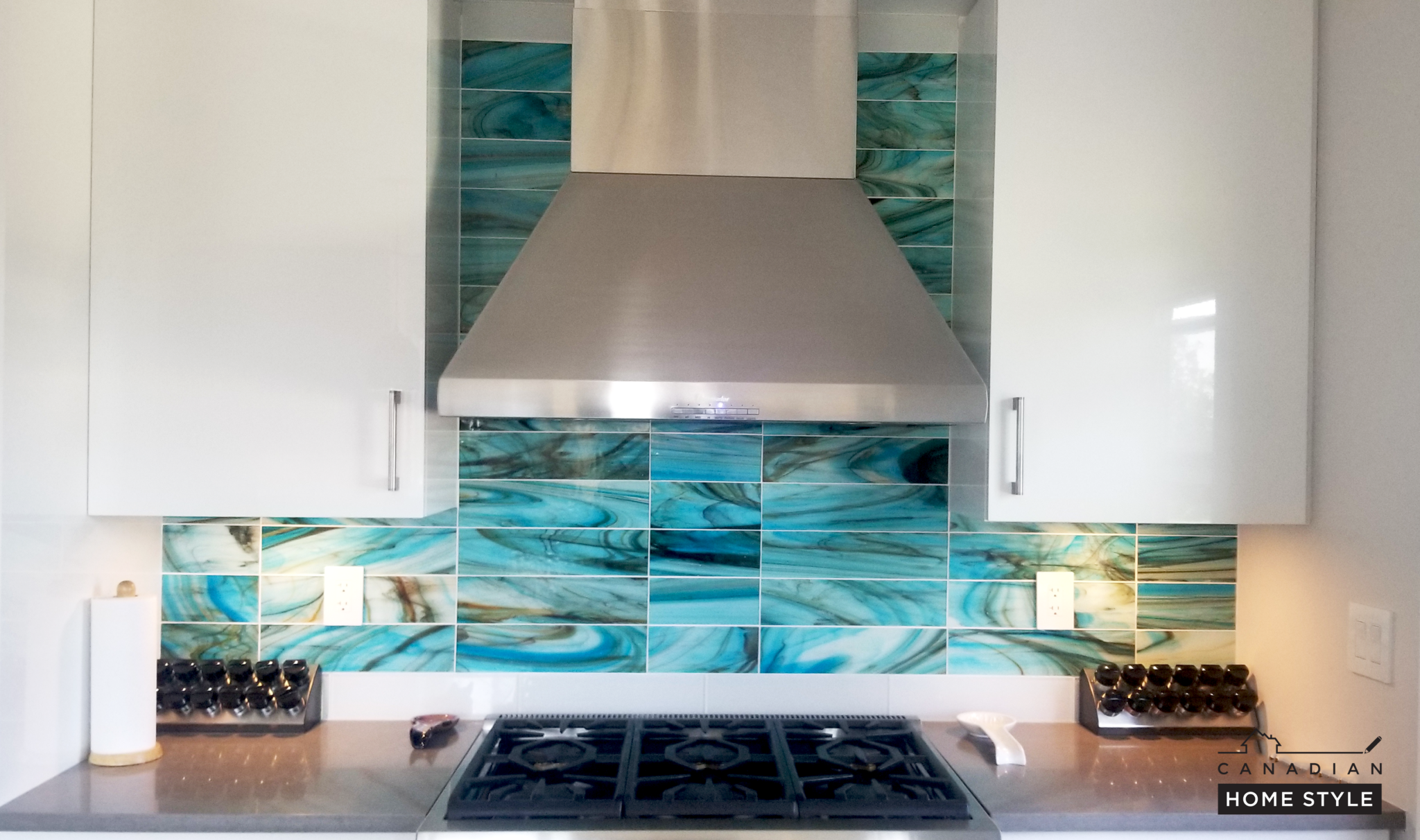 Turquoise marbled glass backsplash with stainless chimney hood in a Canadian Home Style kitchen renovation