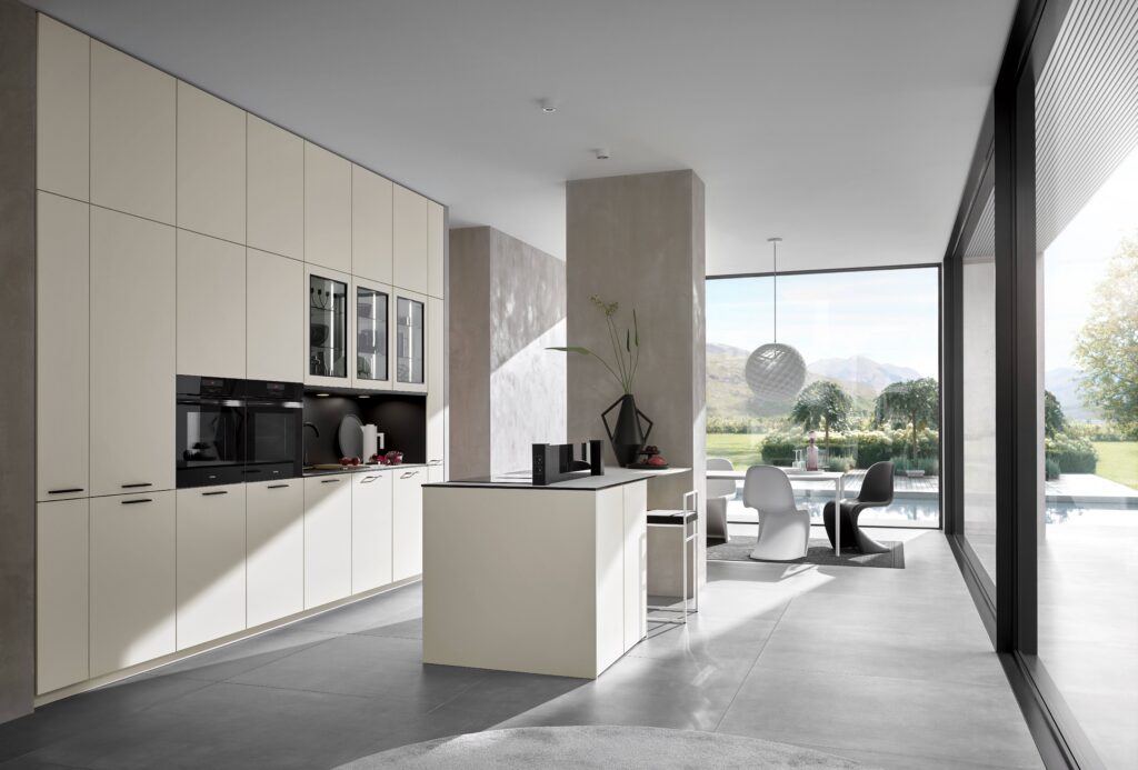 Cream handleless Bauformat kitchen cabinets in an open-plan living space