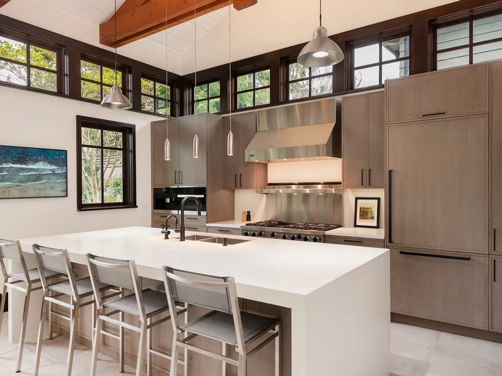 A modern kitchen featuring a center island and bar stools, offering Vancouver services.