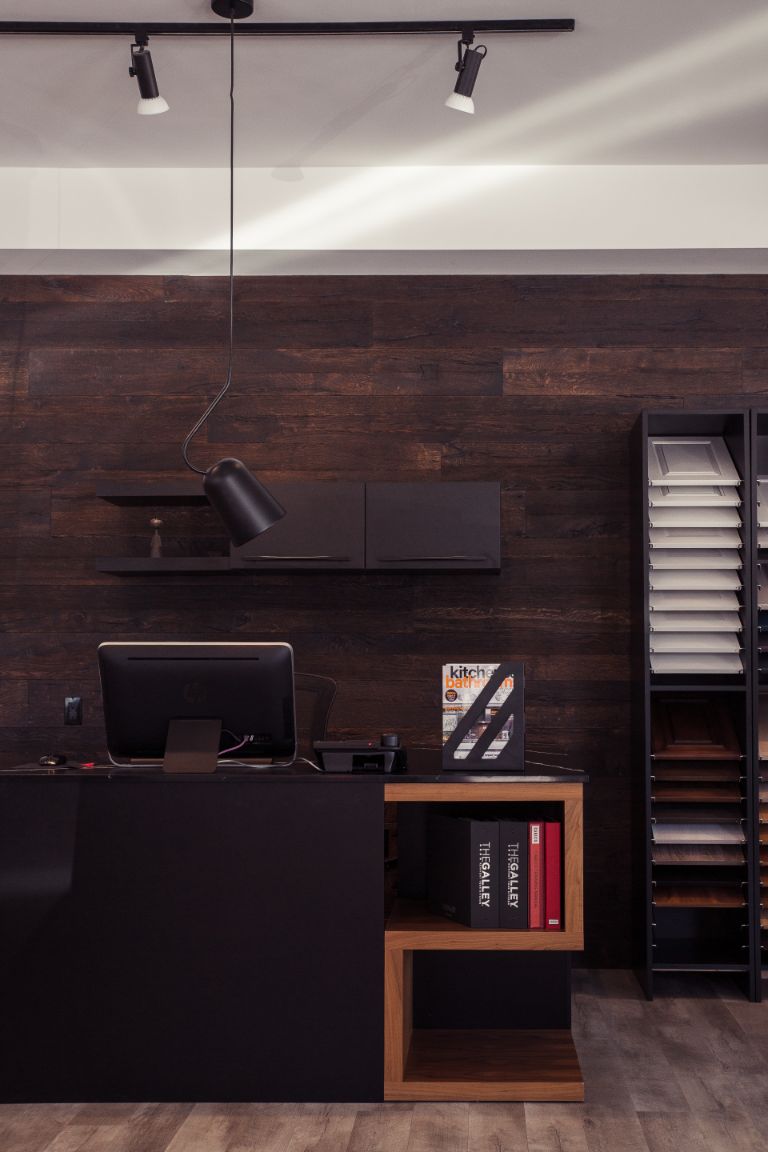A modern office with Canadian Home style, featuring a black desk and wooden walls.