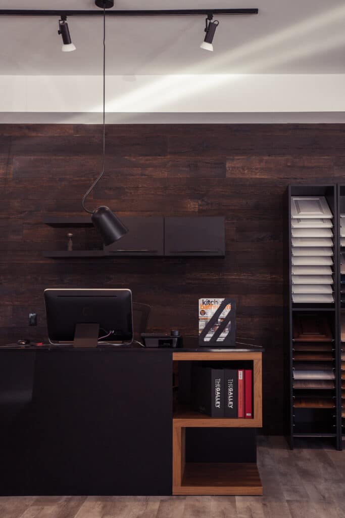 A modern office with a black desk and wooden walls, showcasing elements of Canadian Home Style.