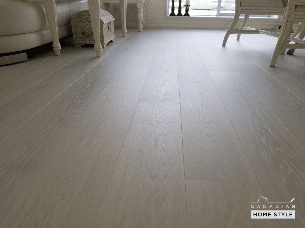 A white wooden floor in a living room, nailed down using a flooring nailer.