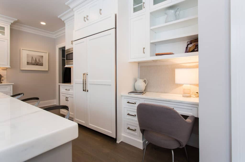 A white kitchen with a desk and MDF kitchen cabinet doors.