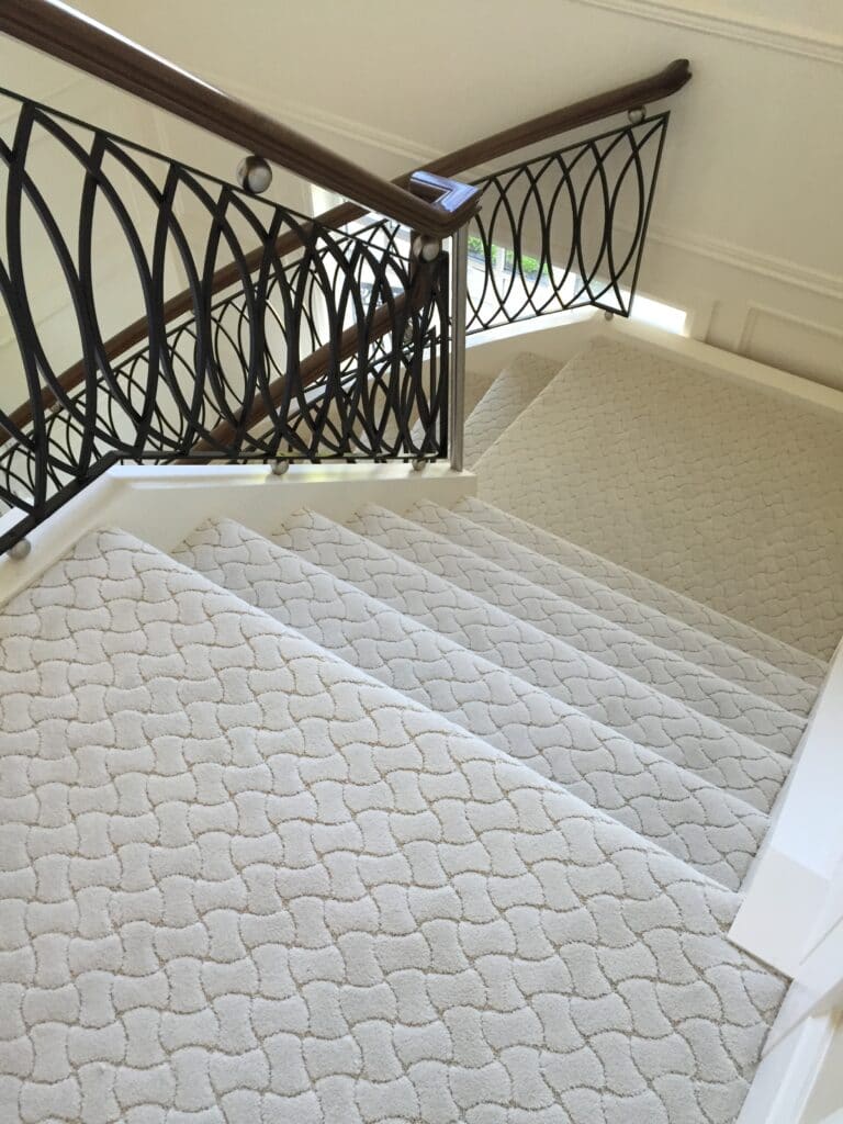 A staircase with a white carpet.