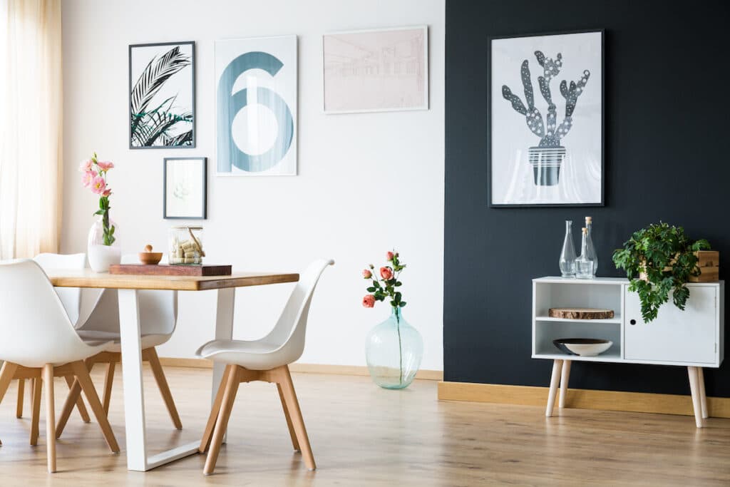 A dining room with black walls and white chairs, featuring Vancouver cork flooring.
