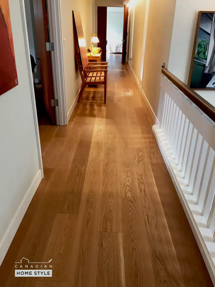 A hallway with a Lauzon hardwood floor and a picture on the wall.