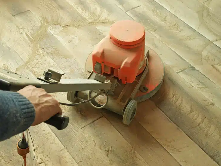 A person in Vancouver using a machine to sand and refinish their hardwood flooring.