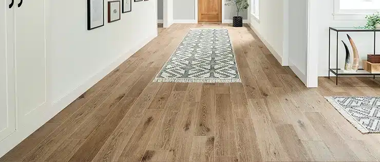 A hallway with Mannington Adura wood floors and a rug.