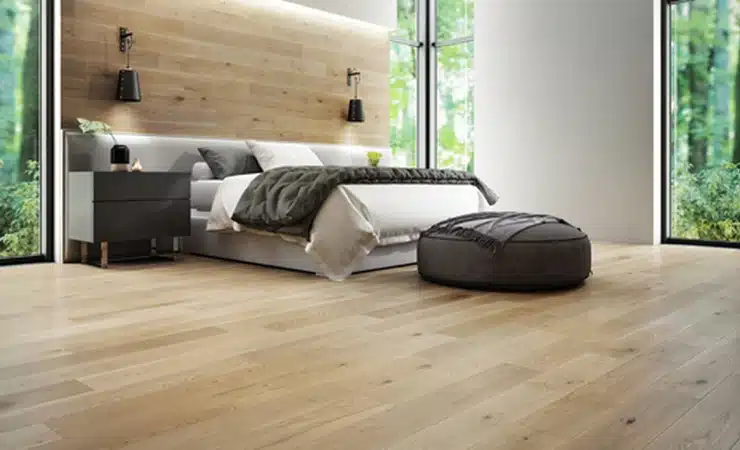 A bedroom with Mercier hardwood floors and a cozy bed.