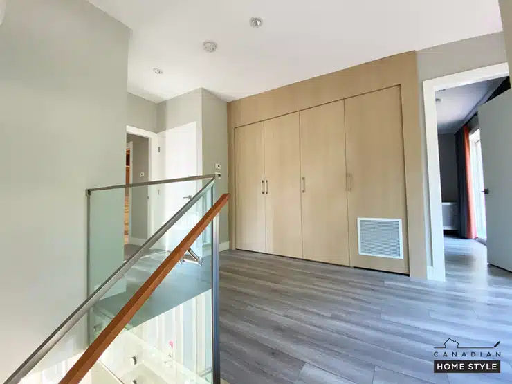 A hallway in a home with wood floors and a stairway featuring waterproof laminate flooring.