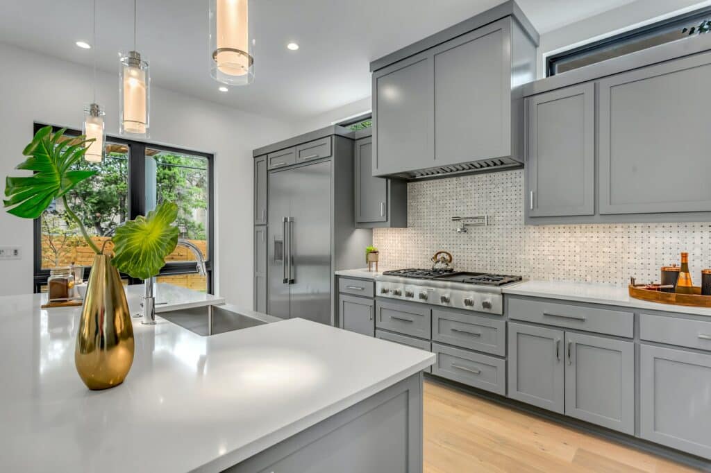 A modern kitchen with gray cabinets and stainless steel appliances, designed for low maintenance.