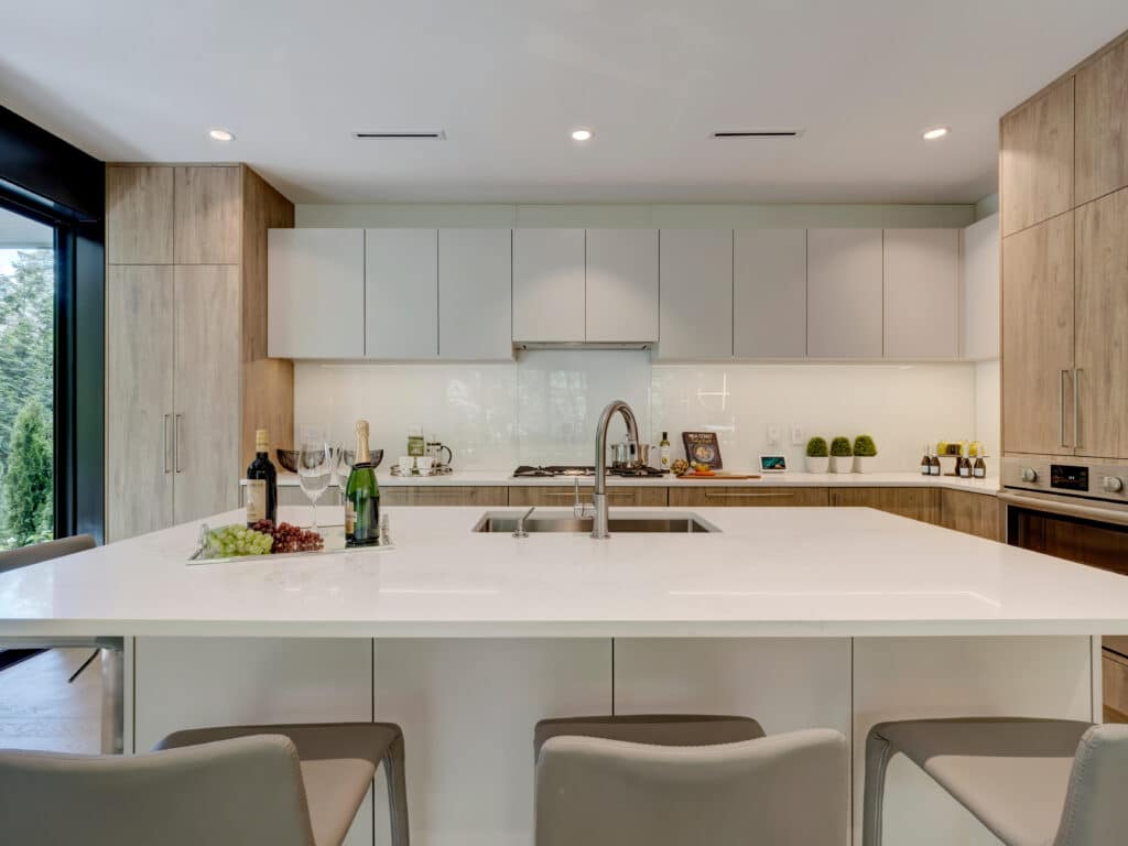 A modern kitchen in Vancouver with white cabinets and a center island.