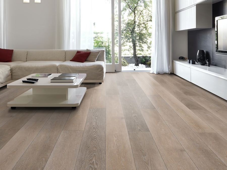 A living room with white furniture and beautiful hardwood flooring.