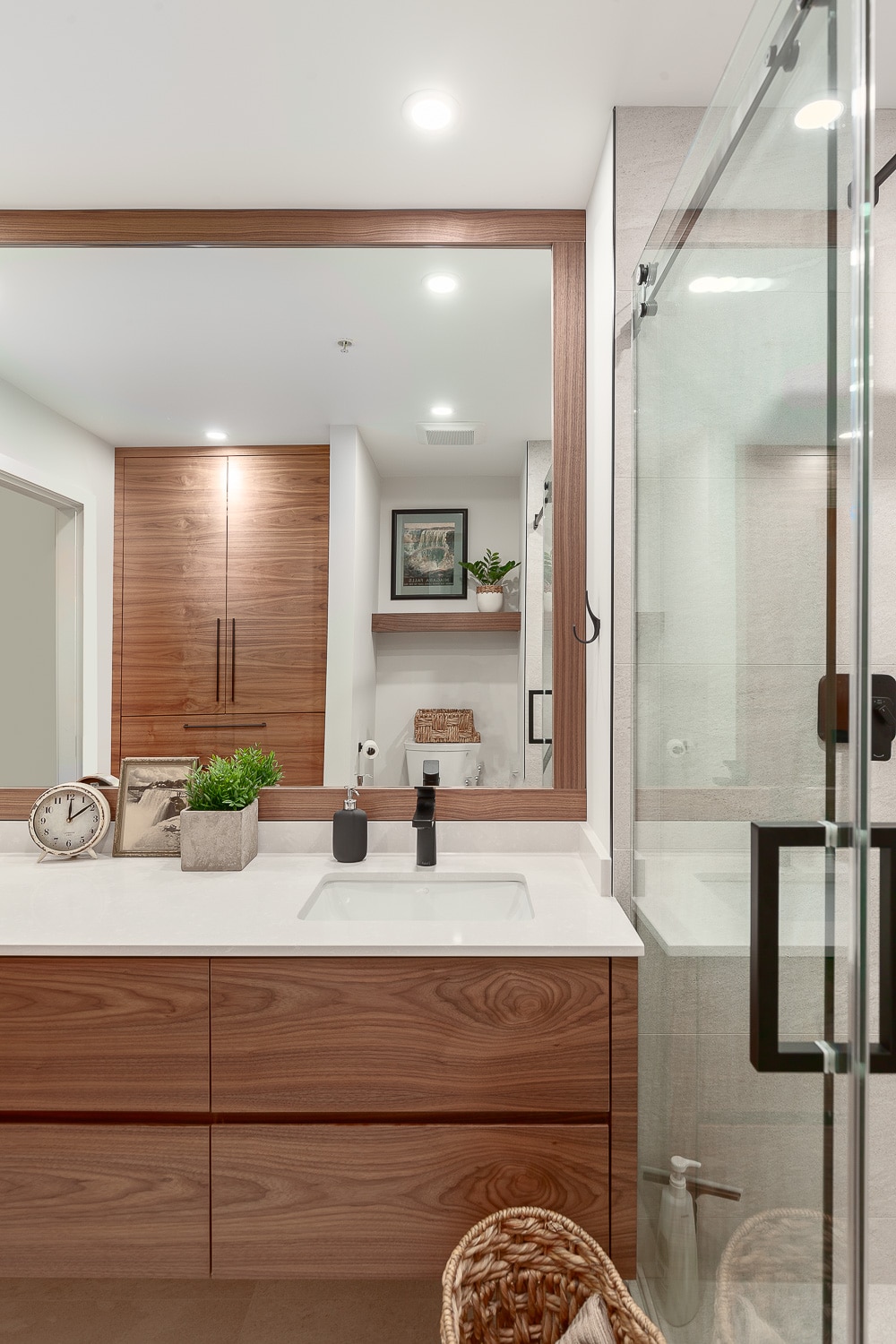 Bathroom Gallery: A modern bathroom with wood cabinets and a large mirror.