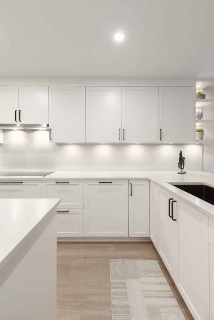 A white kitchen with wood floors and white cabinets is featured in this Bathroom Gallery.