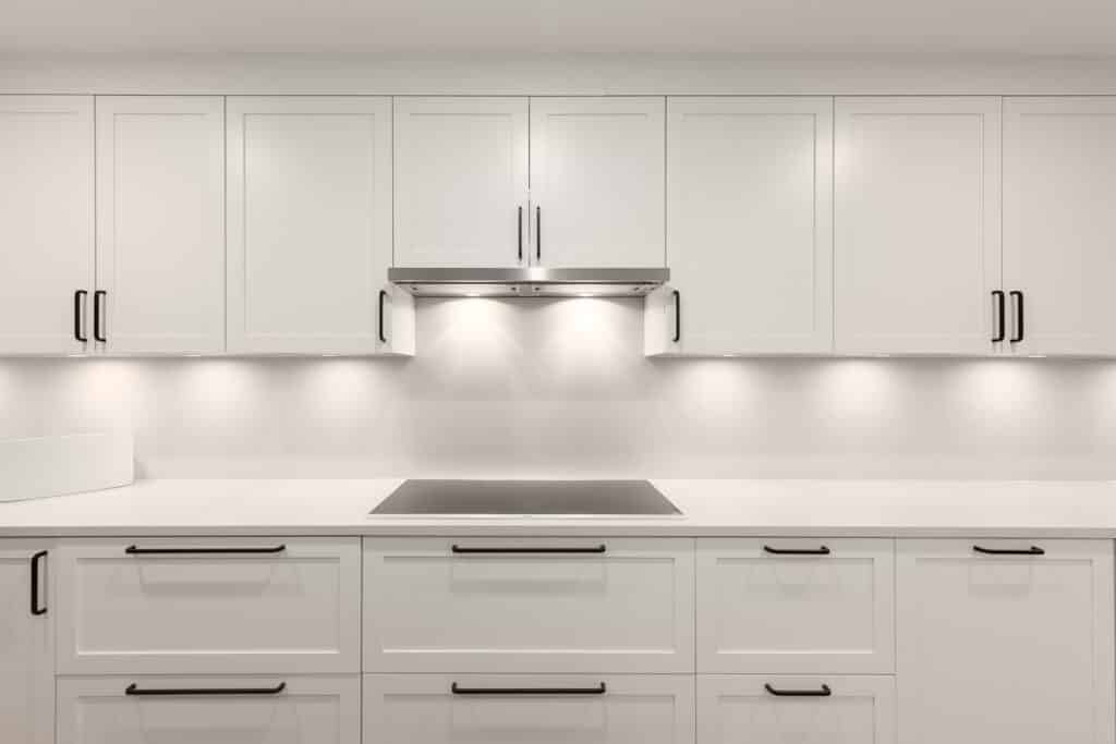 A white kitchen with stainless steel appliances.