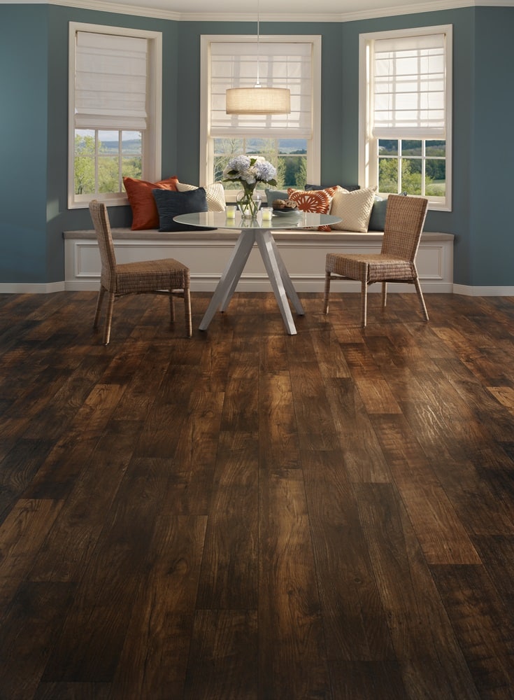 A dining room with wood floors and blue walls beautifully showcases the timeless elegance of vinyl plank flooring.
