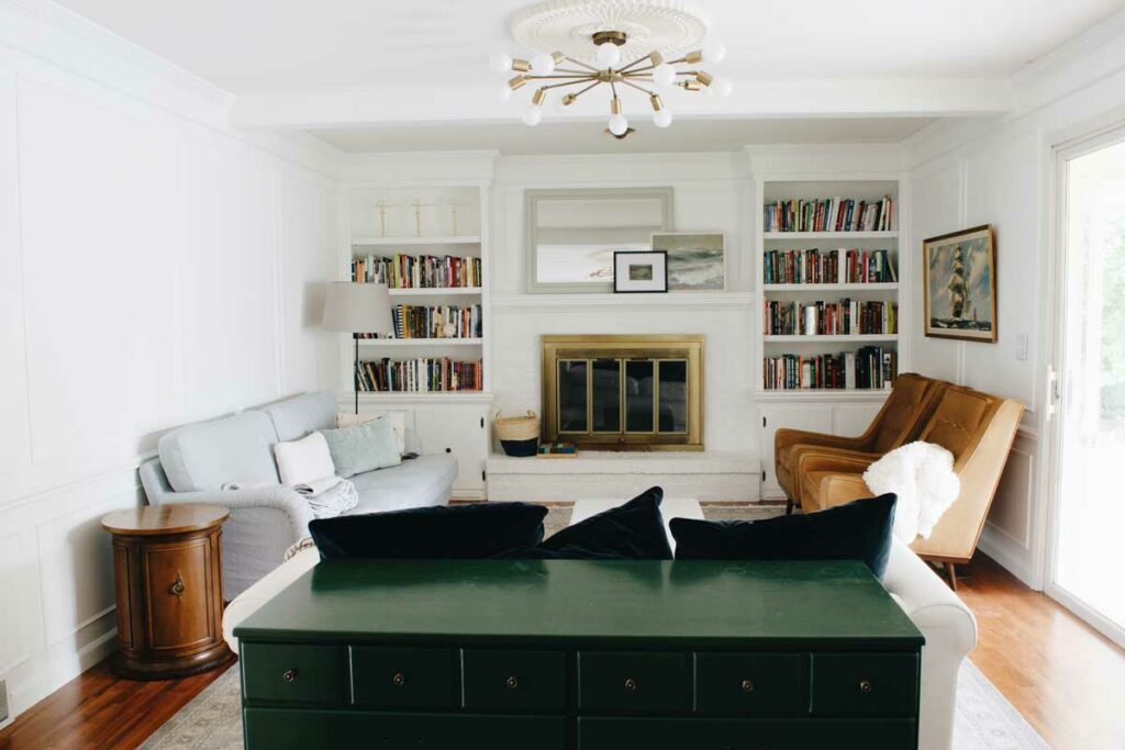 A living room with a fireplace and a green table.