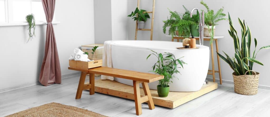 A bathroom with a bathtub and plants on a wooden bench, showcasing the perfect combination of wood and waterproofing.