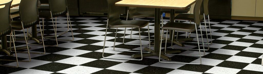 A restaurant with a stylish black and white checkered floor, showcasing the benefits of Vinyl Composition Tile (VCT).