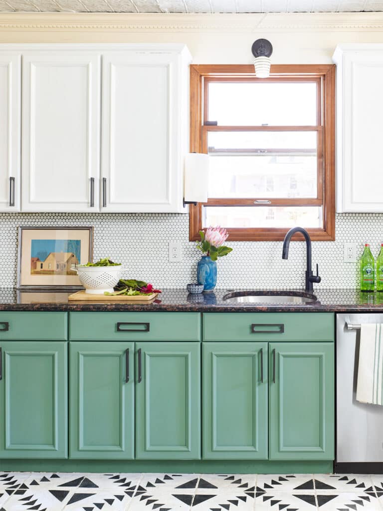 A kitchen with green cabinets and white cabinets.