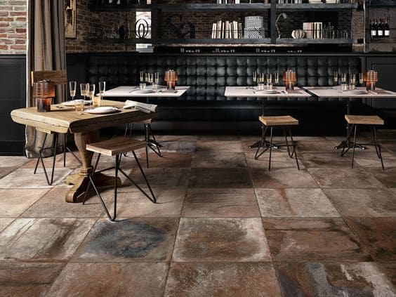 A restaurant with a beautiful tiled floor made of stone, complemented by well-placed tables.