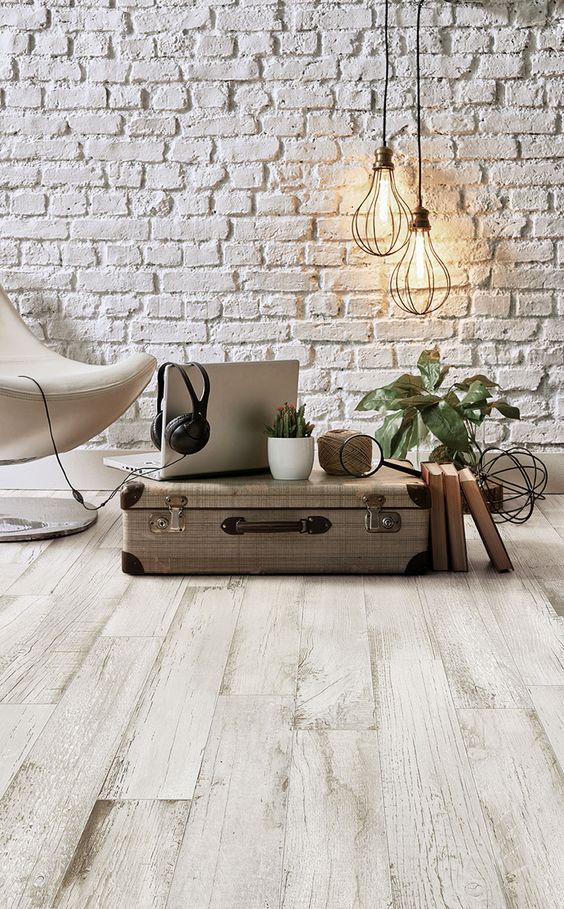 A living room with white laminate wood floors and a suitcase.