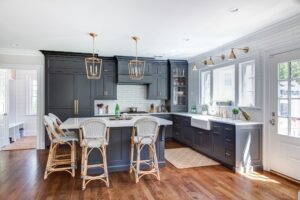 A kitchen with a large island and chairs.