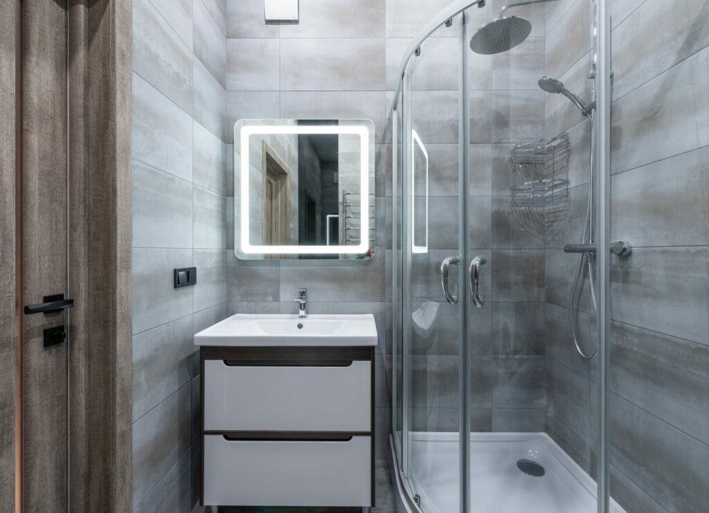 A modern bathroom with a glass shower stall and sink.