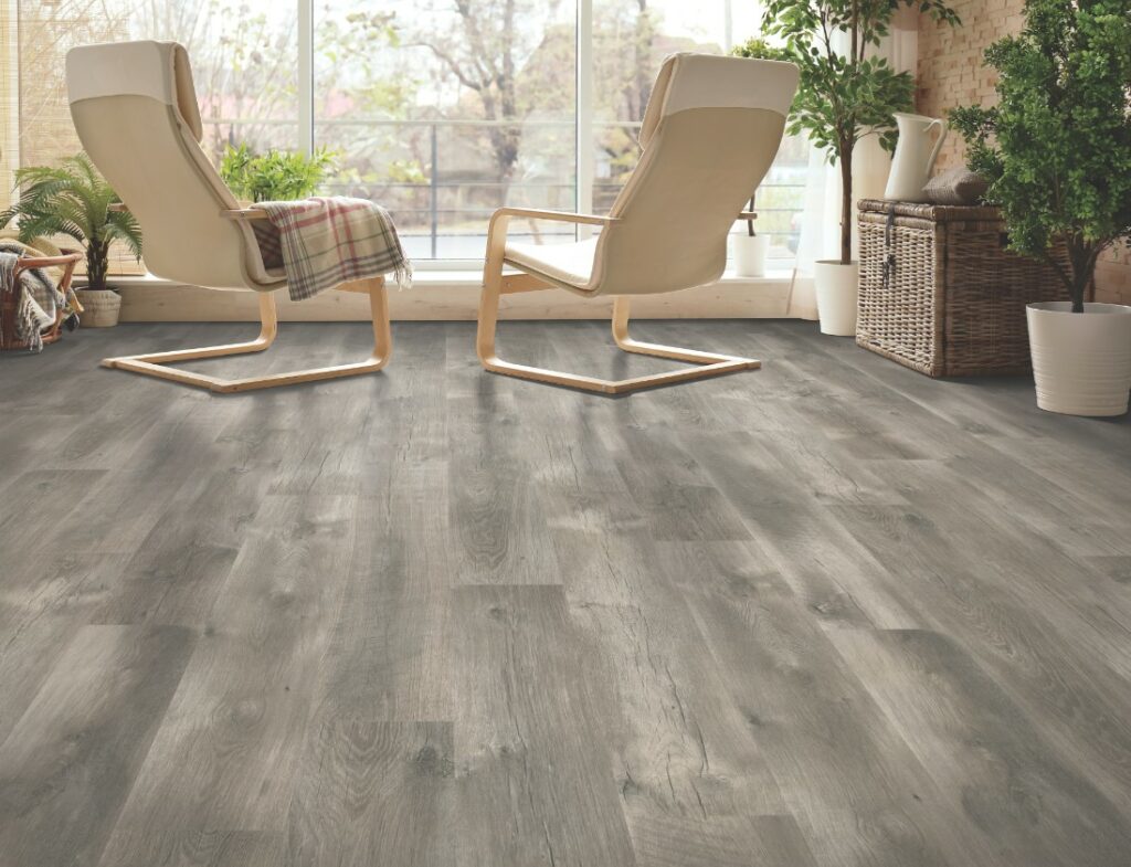 A living room with grey wood floors and chairs.