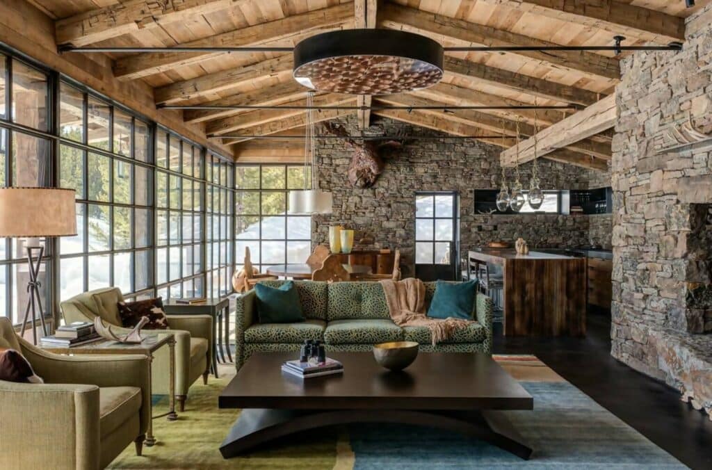 A living room with stone walls and a fireplace.