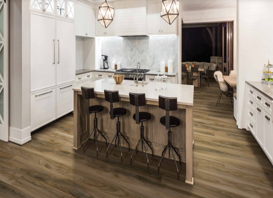A kitchen with Karastan luxury vinyl plank flooring and bar stools.