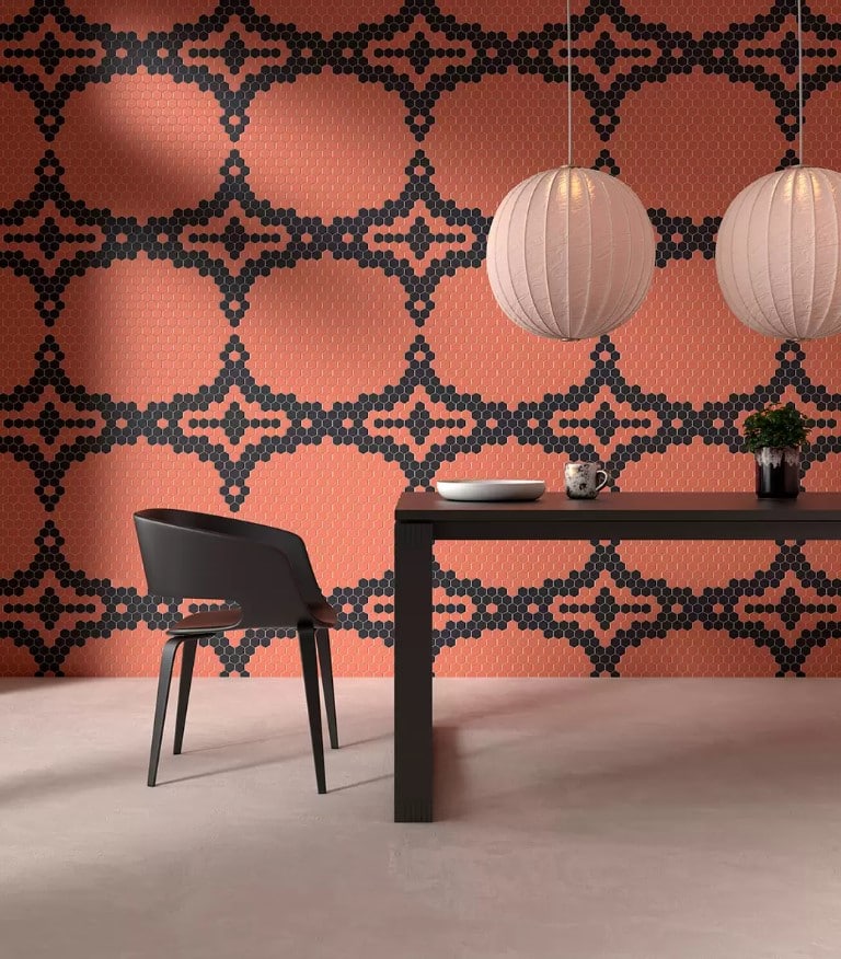 A dining room with an orange and black wallpaper that follows the tile trends for covering in 2023.