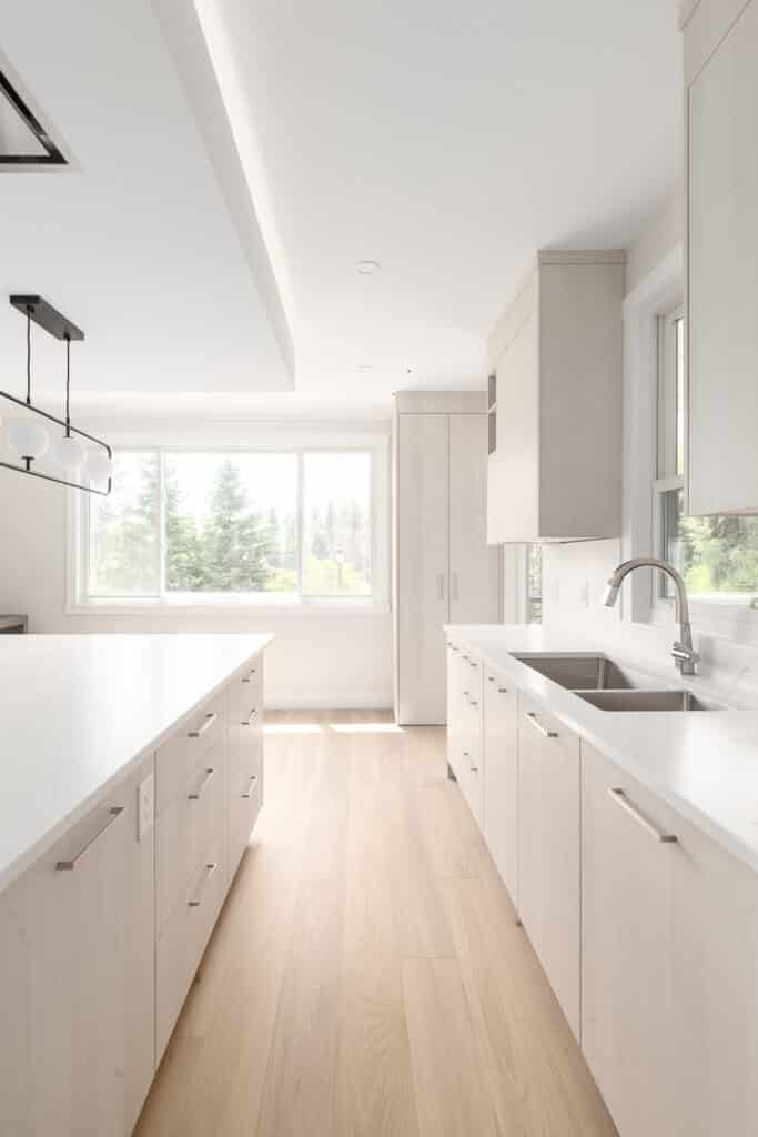 2024 Kitchen Design Trends: A modern kitchen with sleek white cabinets and warm wood floors.