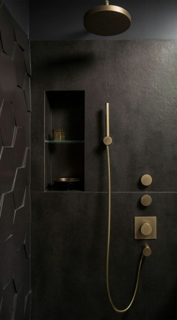 A luxurious black and gold bathroom renovation in West Vancouver featuring a sleek shower head.