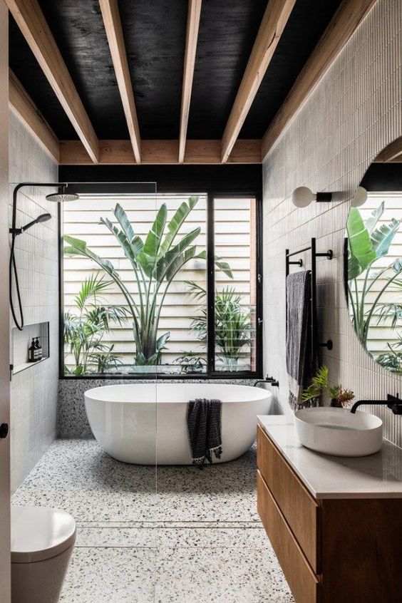 A modern black and white bathroom renovation in West Vancouver featuring a luxurious tub and stylish sink.