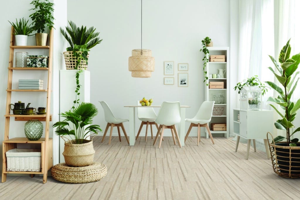 A white living room with plants and a wooden floor made of cork.